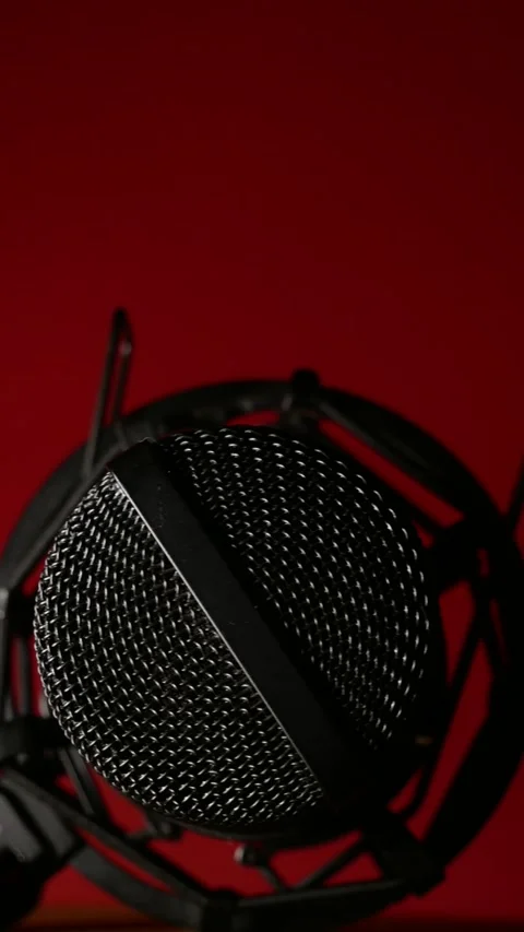 Studio microphone rotating on dark red background in close-up backlight. Podcast Stock Footage 310231451