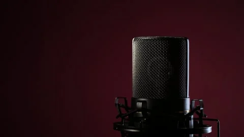 Studio microphone rotating on dark red background with backlight. Podcast Stock Footage 310238289