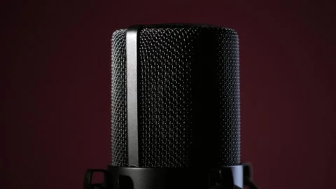 Studio microphone rotating on dark red background with backlight. Podcast Stock Footage 310354275