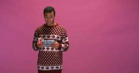 Studio, one friend upstages the other with his stack of Christmas presents Stock Footage 115515216
