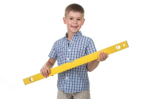 Studio picture of a cute builder boy in a blue checkered shirt, holding a big Stock Photos