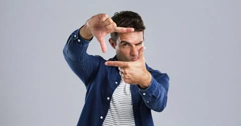 Studio, portrait and man with frame, confident or border with hands for Stock Photos