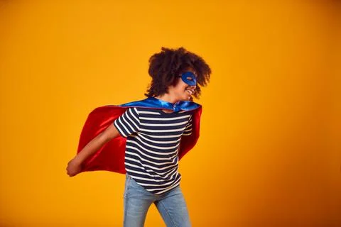 Studio Portrait Of Boy Dressed As Comic Book Superhero Against Yellow Background Stock Photos