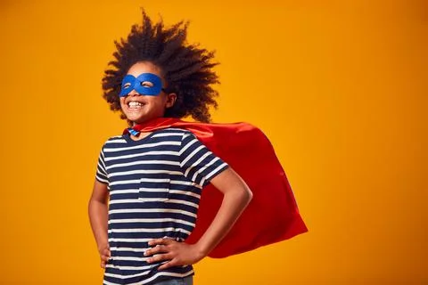 Studio Portrait Of Boy Dressed As Comic Book Superhero Against Yellow Background Stock Photos
