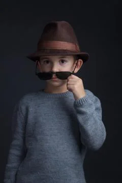 Studio portrait of a boy in a grey sweater, brown hat and sunglasses Stock-Fotos