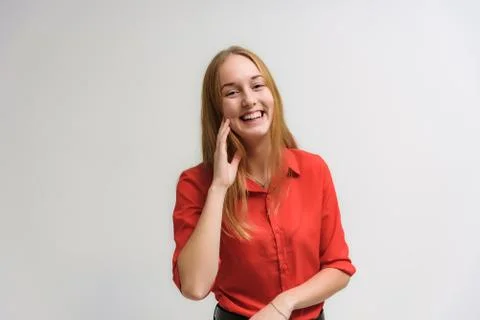 Studio portrait on the camera of a smiling beautiful girl with long hair talk 스톡 사진