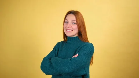 Studio portrait of confident smiling young woman laughing against yellow Stock Footage 148287794