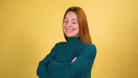 Studio portrait of confident smiling young woman laughing against yellow Stock Footage 148290081