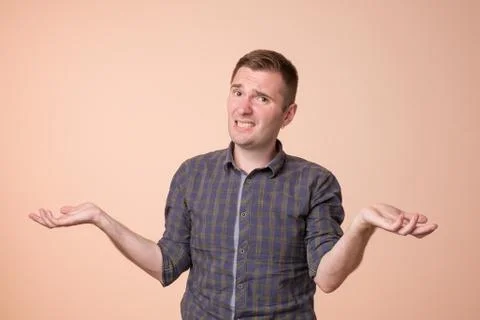 Studio portrait of confused handsome guy showing I have no idea gesture. Stock Photos