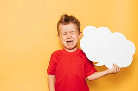 Studio portrait of a crying boy with a clean white board in the shape of a cloud Stock Photos