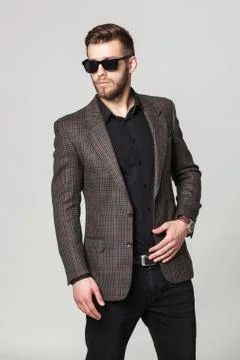 Studio portrait of handsome elegant young man in brown jacket posing. Stock-Fotos
