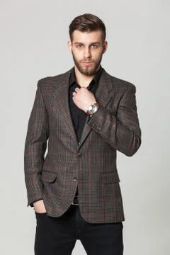 Studio portrait of handsome elegant young man in brown jacket posing. Foto stock
