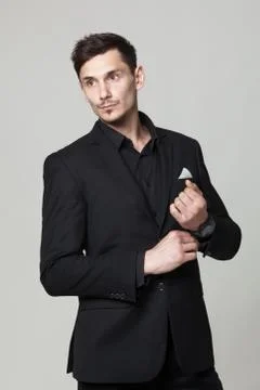 Studio portrait of handsome elegant young man in black  clothes posing. Stock Photos