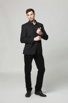 Studio portrait of handsome elegant young man in black  clothes posing. Stock Photos