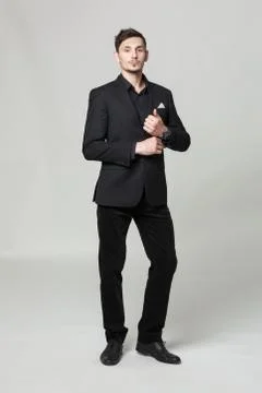 Studio portrait of handsome elegant young man in black  clothes posing. Stock Photos