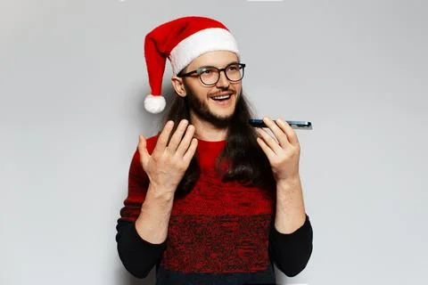 Studio portrait of handsome smiling guy. Talking on smartphone by speakerph.. Stock Photos
