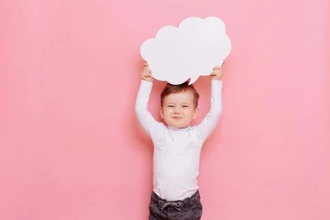 Studio portrait of a happy boy with a clean white board in the shape of a cloud Stock Photos
