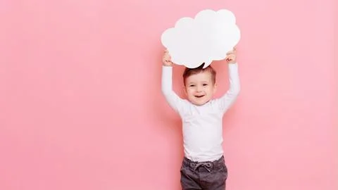 Studio portrait of a happy boy with a clean white board in the shape of a cloud Stock Photos