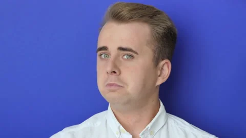 Studio portrait of a happy european guy smiling and gesturing at the camera Stock Footage 221581995