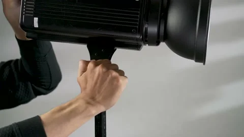 Studio portrait of a man setting up the lighting for a shoot Video stock 156019736