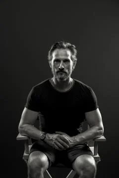 Studio portrait of mid aged man sitting on chair. Stock Photos