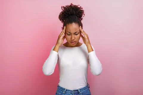 Studio portrait mulatto touching pressed herself head with her hands.Concept  Stock Photos