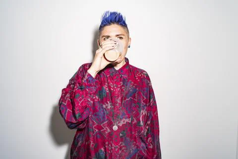 Studio portrait of non-binary person drinking from disposable cup Stock Photos