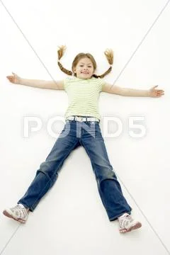 Studio Portrait of Smiling Girl lying down with arms and legs spread Stock Photos