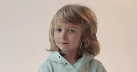 Studio portrait of a smiling handsome boy with long hair in a blue suit Video stock 253391202