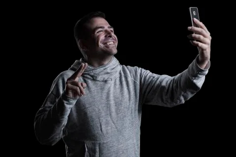 Studio portrait of a smiling man taking a selfie Stock Photos