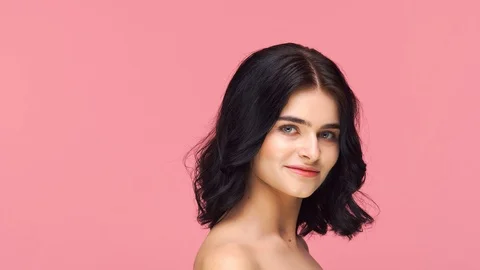 Studio portrait of young and beautiful brunette woman over pink background. Skin Stock Footage 125190894