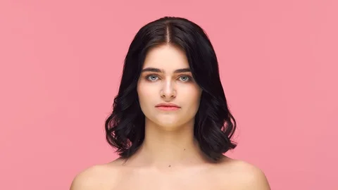 Studio portrait of young and beautiful brunette woman over pink background. Skin Stock Footage 125473208