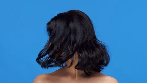 Studio portrait of young and beautiful brunette woman over blue background. Skin Stock Footage 126209610