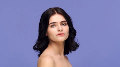 Studio portrait of young and beautiful brunette woman over purple background Stock Footage 126690422