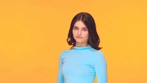 Studio portrait of young and expressive teenage girl over yellow background. Stock Footage 125475100