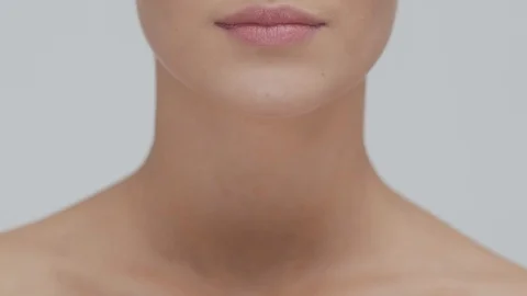 Studio portrait of young, beautiful and natural blond woman applying skin care Stock Footage 117698991