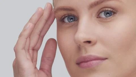 Studio portrait of young, beautiful and natural blond woman applying skin care Stock Footage 263148006