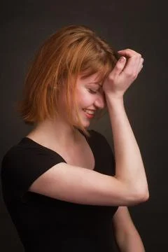 Studio portrait of a young brown-haired woman, on a black background Stock Photos