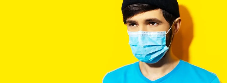 Studio portrait of young hipster guy wearing medical flu mask. Stock Photos
