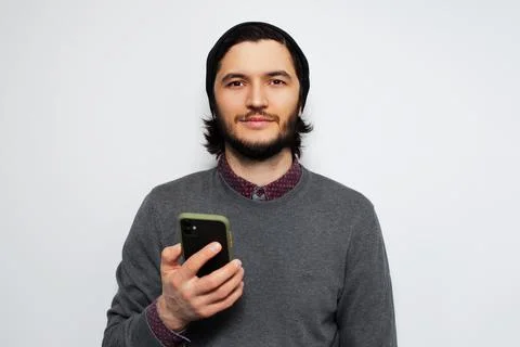 Studio portrait of young man using smartphone on white background. Stock Photos