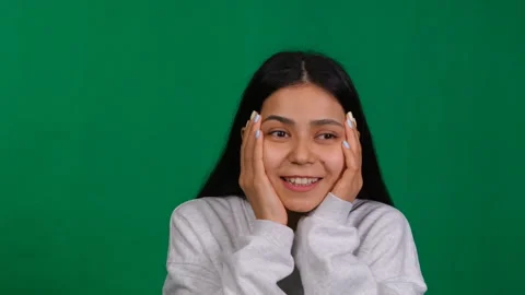 In a studio portrait, a young woman's expression reflects the thrill of success Video stock 267811346