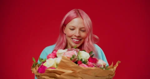 Studio shoot of happy and surprised young woman with pink hair holding bouquet Stock Footage 153255938
