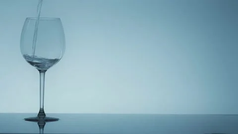 Studio shoot of water pouring into transparent glass on white background Stock Footage 132428845