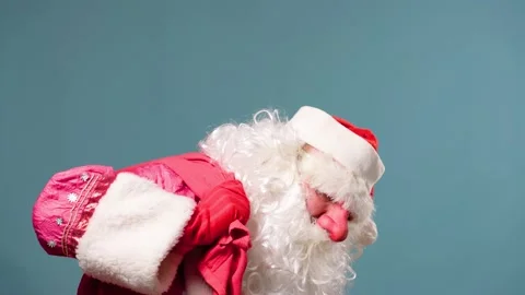 Studio shooting blue background tired Santa Claus throws a red bag with gifts on Stock Footage 211680773