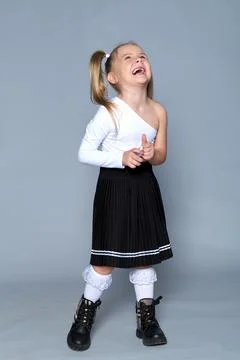 In this studio shot, a 5-year-old girl radiates confidence while wearing a sleek Stock Photos