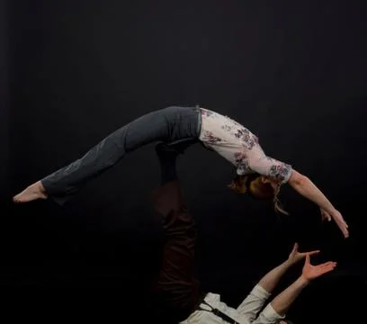 Studio shot of acrobats performing balancing trick Stock Photos