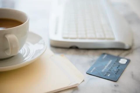 Studio shot of coffee cup, computer keyboard, files and credit card Stock Photos
