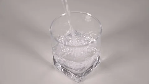 Studio shot of Cola pouring into transparent glass on white table. Stock Footage 126145760