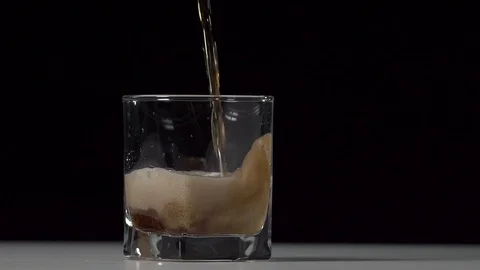 Studio shot of Cola pouring into transparent glass on white table. Stock Footage 126319322