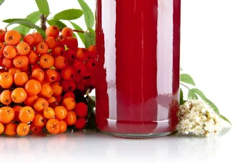 Studio shot of cropped orange ash-berry with blossom, green leaves and jar of Stock Photos